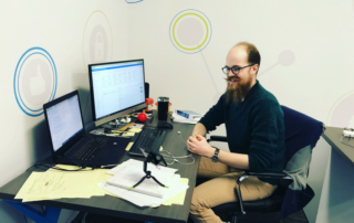 Austin sitting in front of two computers at Brew City Marketing