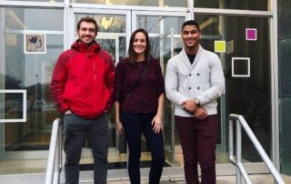 Amanda, SaVaughn, and Nick standing in front of SaintA building