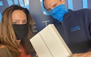 Brew City Marketing team members showing off a brand new iPad for client referrals