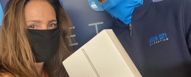 Brew City Marketing team members showing off a brand new iPad for client referrals