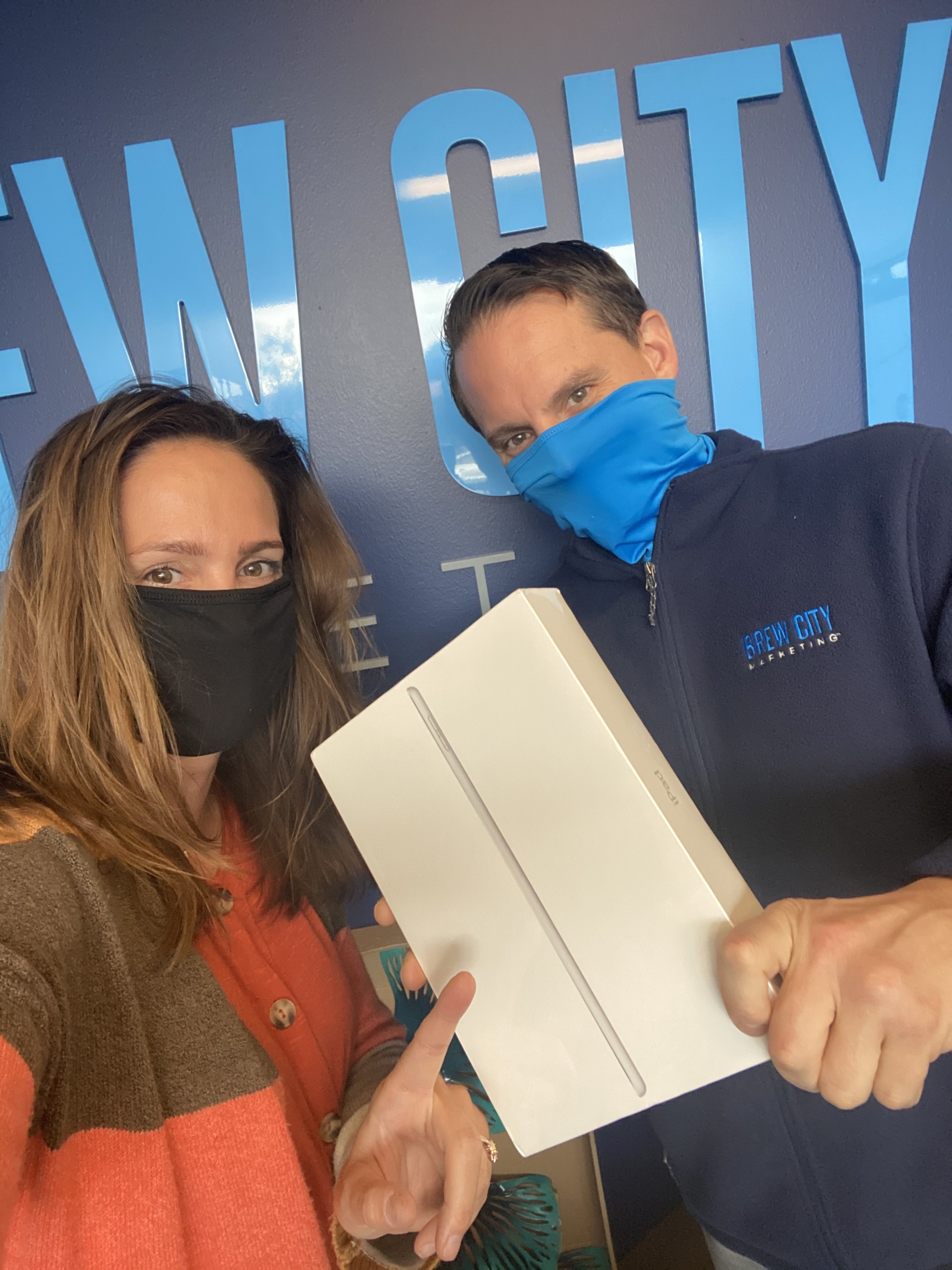 Brew City Marketing team members showing off a brand new iPad for client referrals